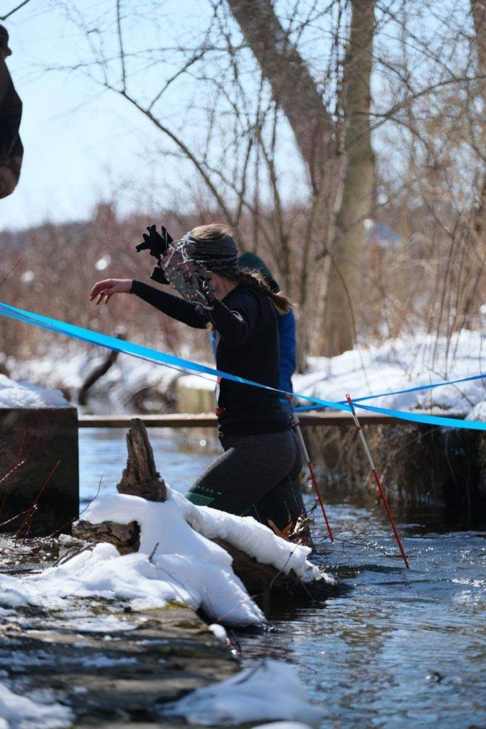 Amie knee deep in a creek crossing