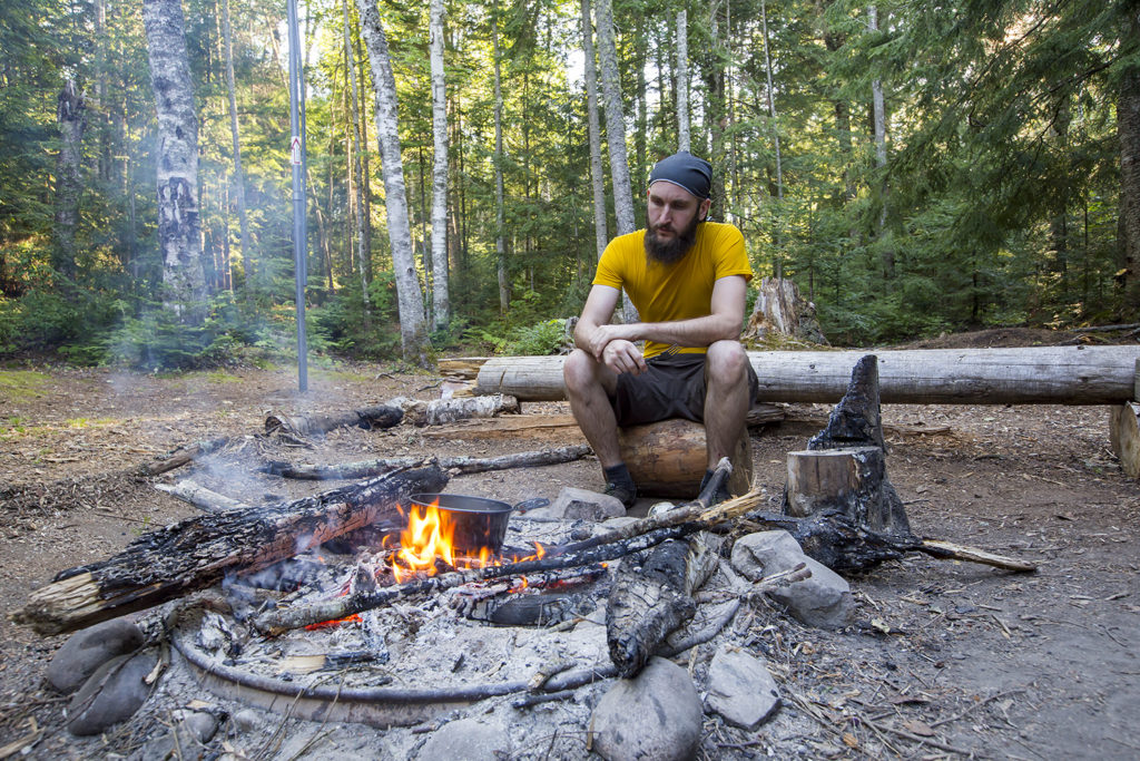 Steve cooking over a community firepit