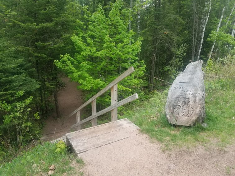 Stairs and sign carved into wood stump to Dead River Falls