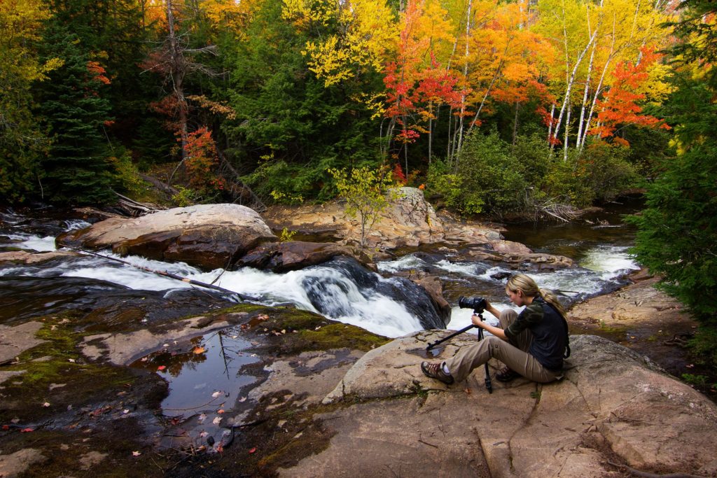 Amie taking a photograph at a waterfall