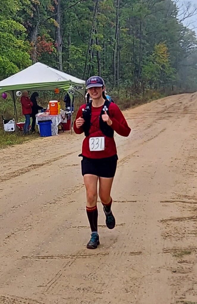 Amie running into an aid station