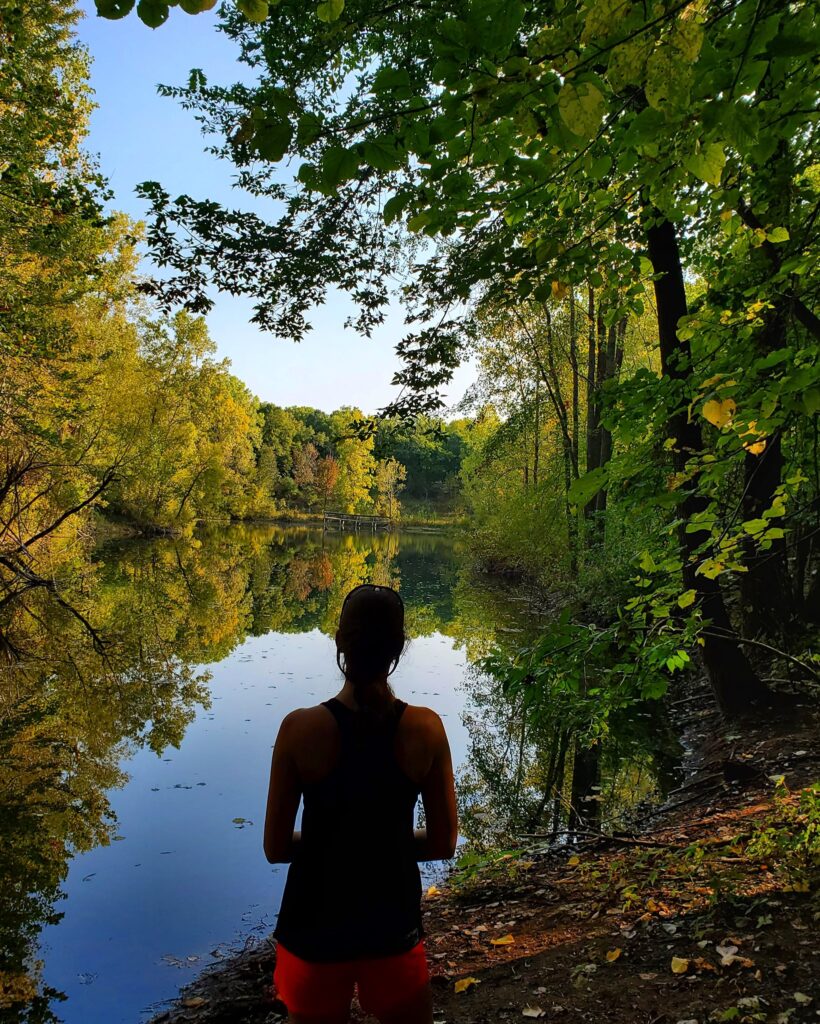 Amie looking at a lake in River Bend Natural Area