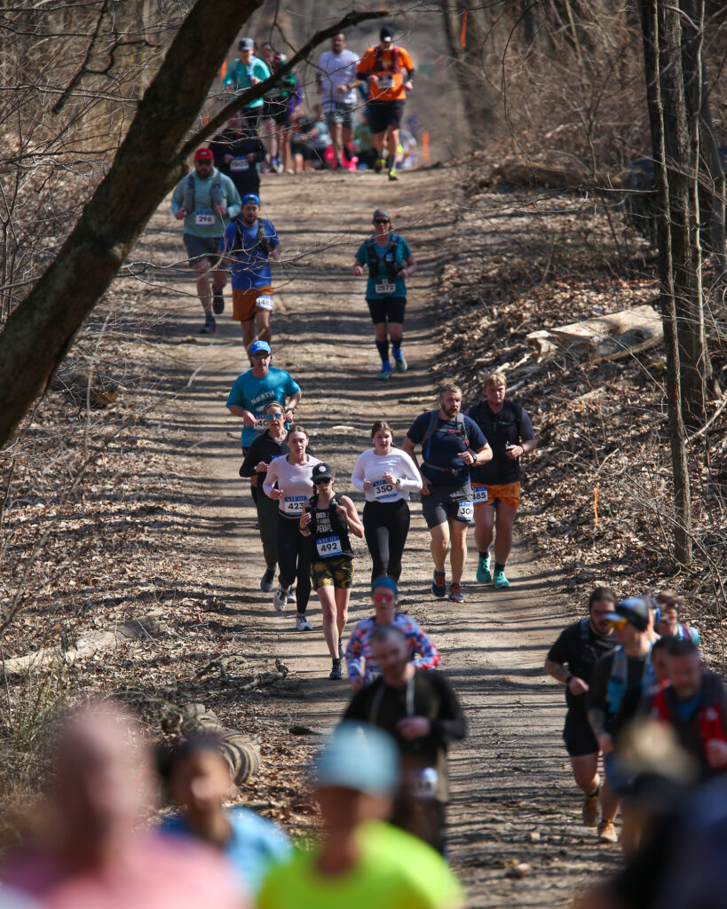 A group of people running on a trail during the Winter Trail Fest - West race