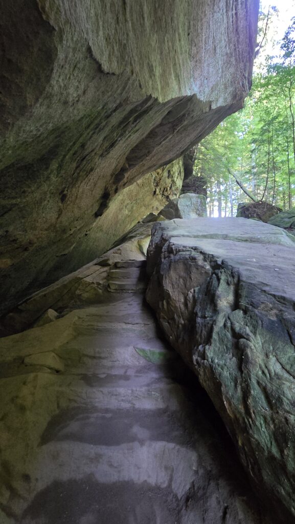 Trail going under a cliff overhang at Cedar Falls