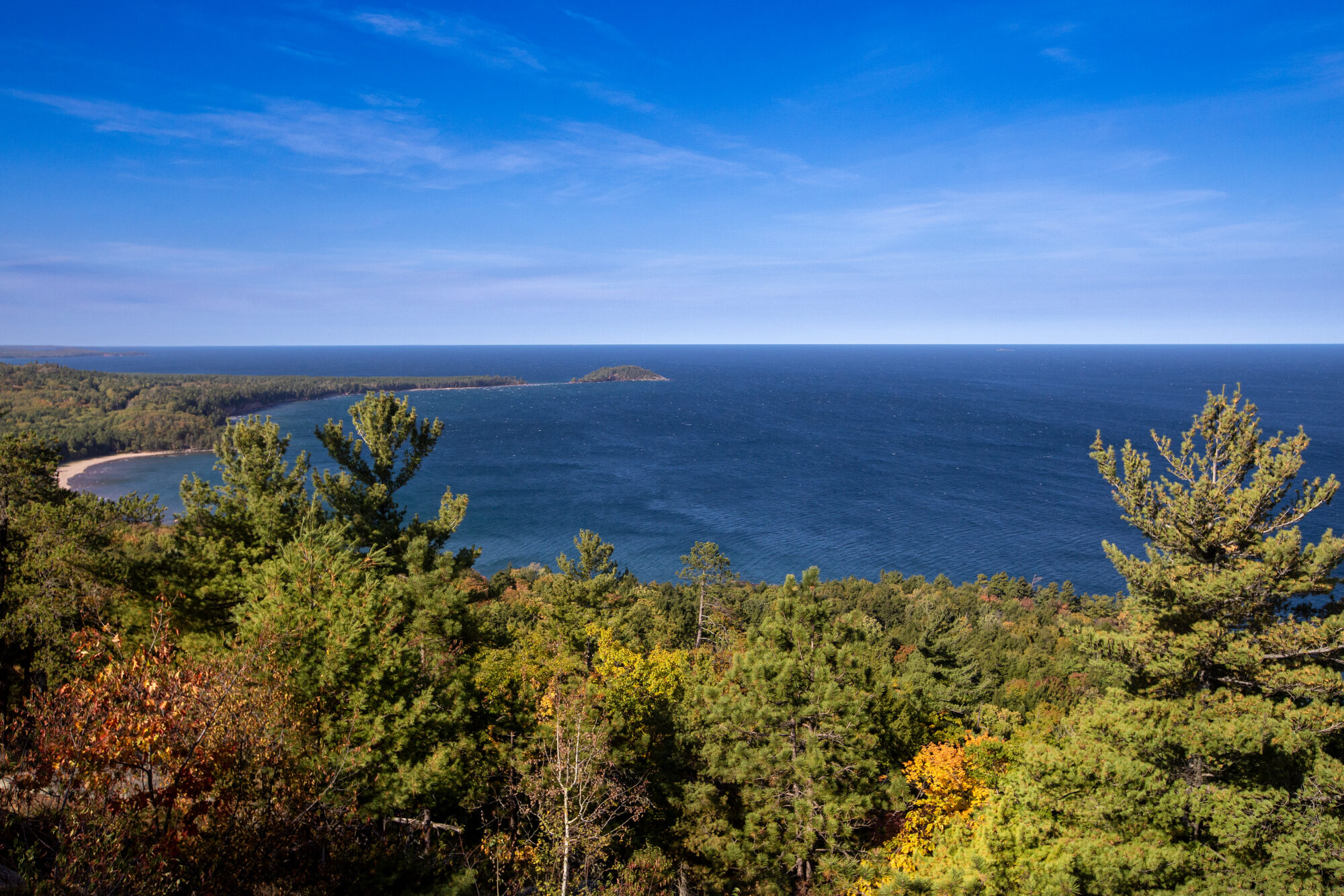 Lake Superior surrounded by yellowing trees and evergreens