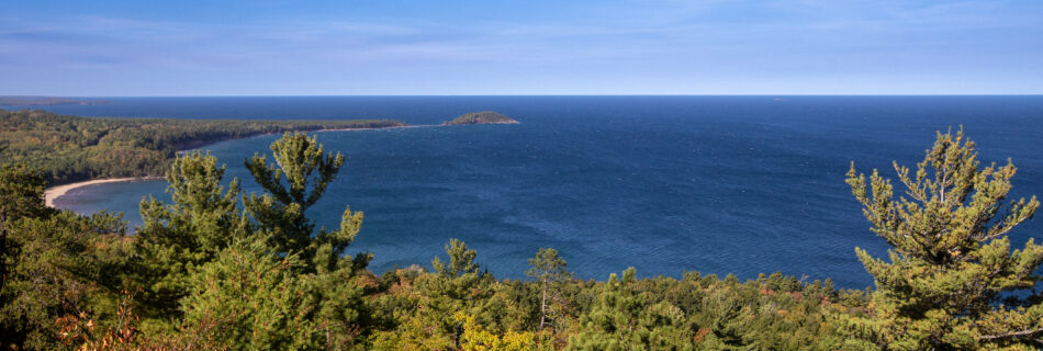 Lake Superior surrounded by yellowing trees and evergreens