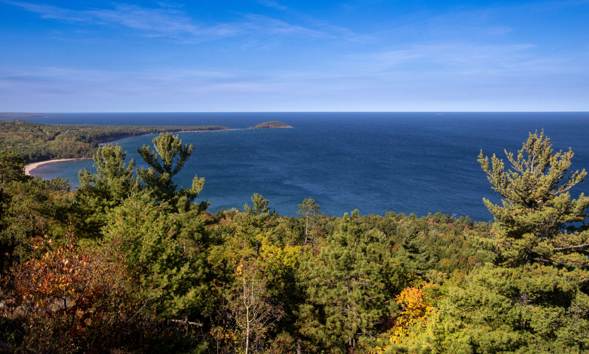 Lake Superior surrounded by yellowing trees and evergreens