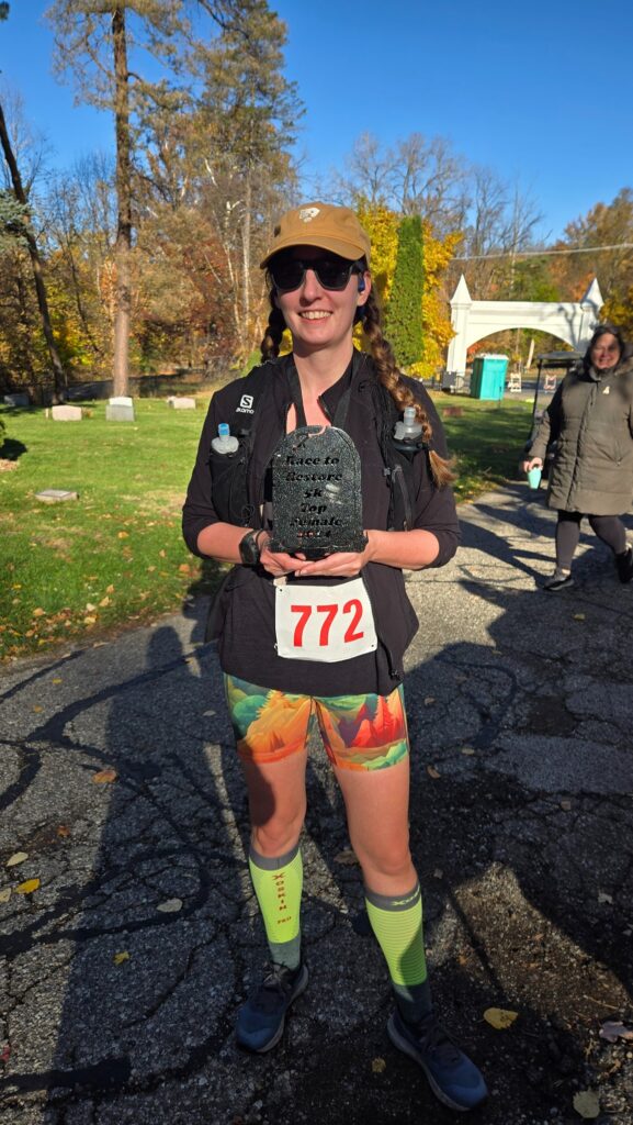 Amie holding the first female finisher medal from Race to Restore 5K