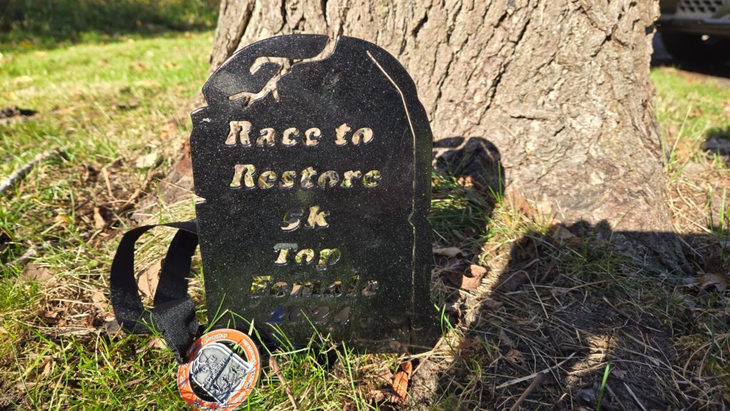 Gravestone medal and finisher medal from Race to Restore