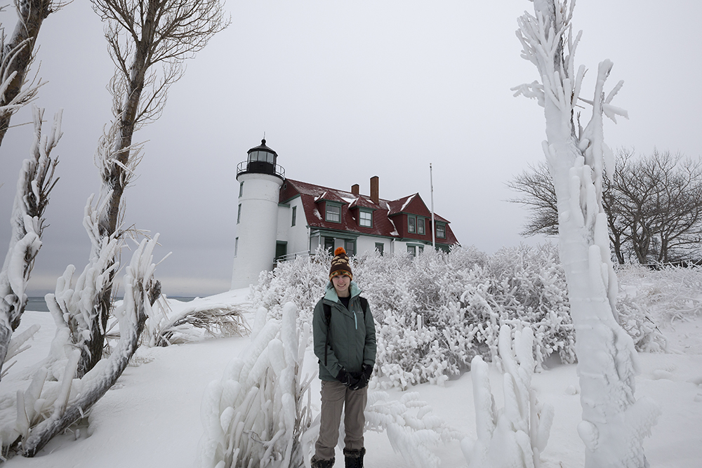 Amie standing in front of a frozen Point Betsie Lighthouse