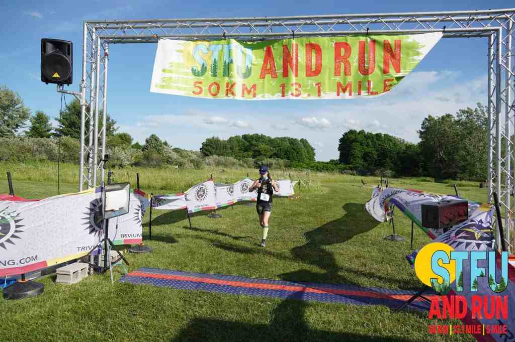 Amie crossing the finish line at the Summer Trail Fest Ultra
