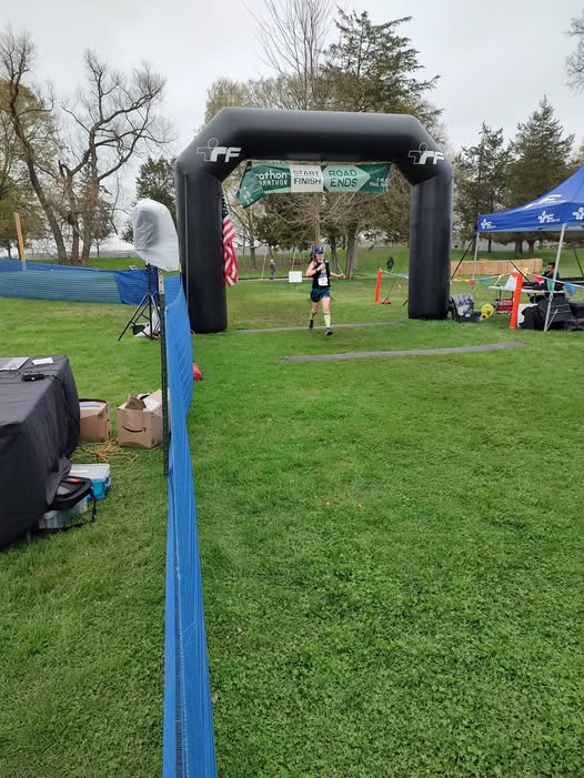 Amie running across the finish line at trail weekend 50K