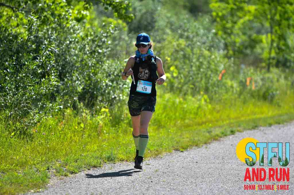Amie running on paved road with an otterpop in her hand